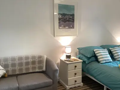 a living room with a couch and a bed and a lamp at Bluebirds villa in Padstow