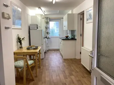 a small kitchen with a table and a dining room at Bluebirds villa in Padstow