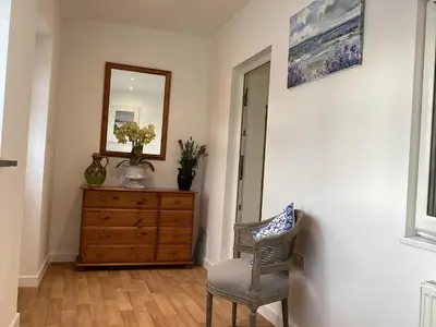 a room with a dresser and a mirror and a chair at Bluebirds villa in Padstow