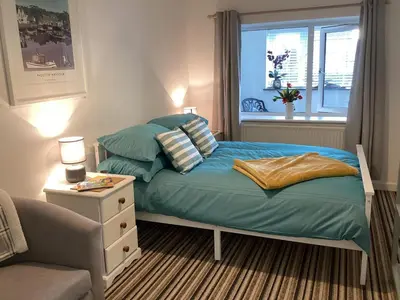 a bedroom with a bed with pillows and a window at Bluebirds villa in Padstow