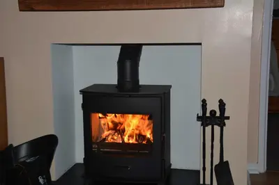 a black stove with a fire in a room at Itldo in Truro