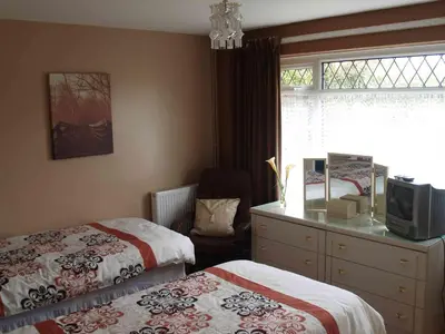 a bedroom with two beds and a dresser and a window at Itldo in Truro