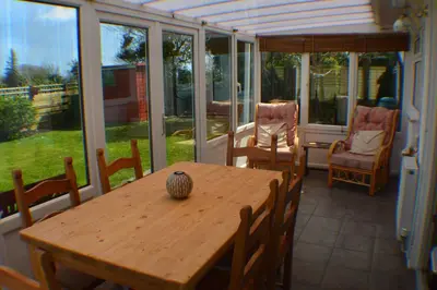 a wooden table and chairs on a screened porch at Itldo in Truro