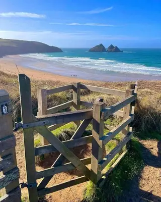 a wooden gate on a beach with the ocean at Newquay Bay Holiday Resort Caravan 142 in Porth