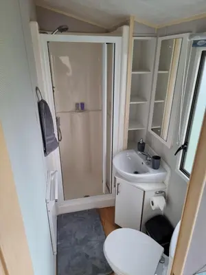 a small bathroom with a shower and a toilet at Newquay Bay Holiday Resort Caravan 142 in Porth