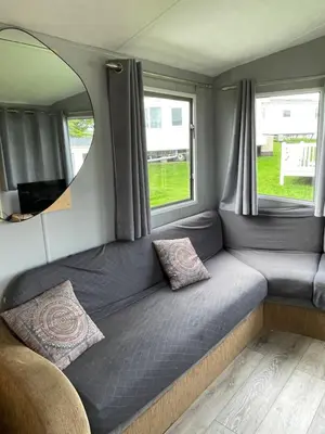 a couch in a room with a tv and windows at Newquay Bay Holiday Resort Caravan 142 in Porth