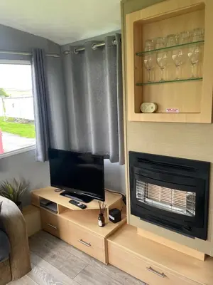 a living room with a tv and a fireplace at Newquay Bay Holiday Resort Caravan 142 in Porth
