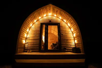 a room with an arched window in a wooden building at Grassington Farm by Wigwam Holidays in Helston