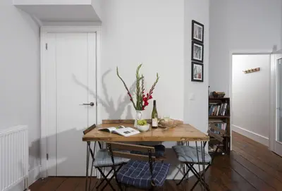 a dining room table with a vase of flowers on it at The Old Carriage Works in Lostwithiel