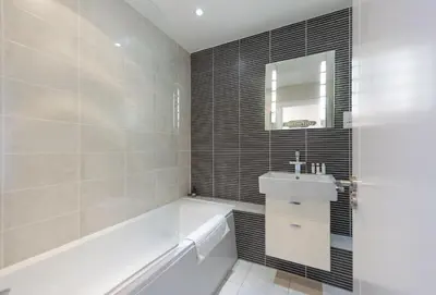 a bathroom with a white tub and a sink at The Old Carriage Works in Lostwithiel