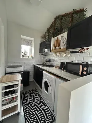a kitchen with a washer and dryer on a counter at Thea Cottage in Perranuthnoe