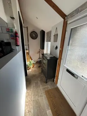 a small kitchen with a refrigerator and a window at Thea Cottage in Perranuthnoe