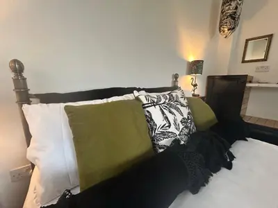 a bed with pillows on top of it at Thea Cottage in Perranuthnoe