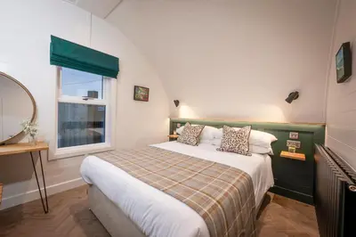 a bedroom with a large bed and a window at POD St Ives - LUXURY GLAMPING ACCOMMODATION in St Ives