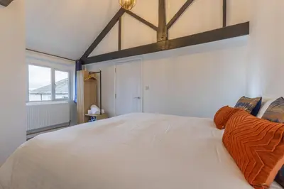 a large white bed in a room with a window at Manor in Bude