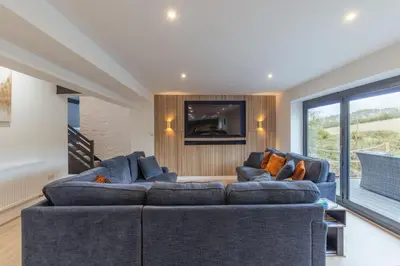 a living room with two blue couches and a television at Manor in Bude