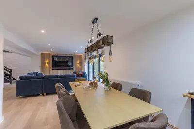 a dining room with a table and a blue couch at Manor in Bude
