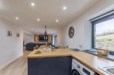 a kitchen and living room with a large window at Manor in Bude