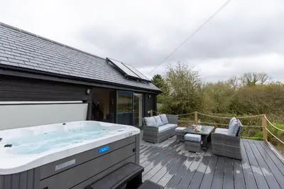 a hot tub on the deck of a house at Manor in Bude