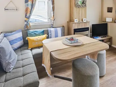 a living room with a couch and a table at Sandy Toes in Newquay