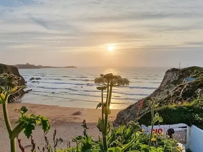 a view of the ocean from a beach at sunset at Sandy Toes in Newquay