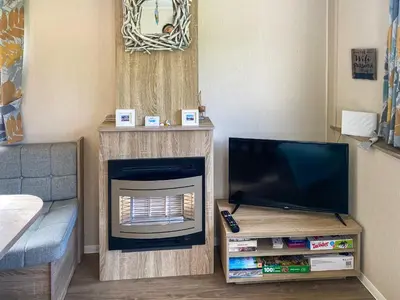 a living room with a flat screen tv and a couch at Sandy Toes in Newquay