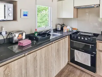 a kitchen with a sink and a stove at Sandy Toes in Newquay