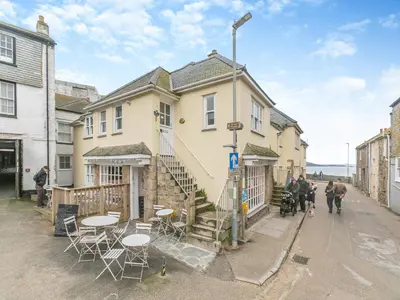 a building with tables and chairs on a street at Fishermans Cottage in St Ives