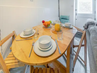 a wooden table with plates and a pitcher of orange juice at Fishermans Cottage in St Ives
