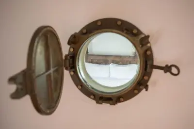 a mirror on a wall with a reflection of a room at Bligh - Treworgie Barton Cottages in Bude