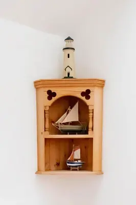 a wooden shelf with a lighthouse on top of it at Bligh - Treworgie Barton Cottages in Bude