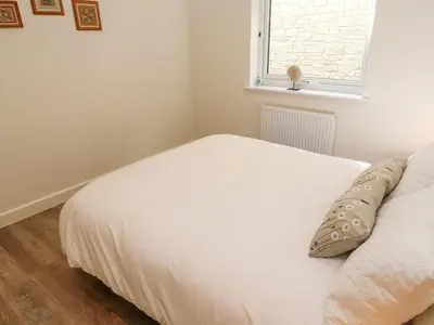 a white bed in a room with a window at 2 The Dunes in Falmouth