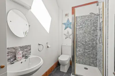 a bathroom with a sink toilet and a mirror at The Stables in Liskeard
