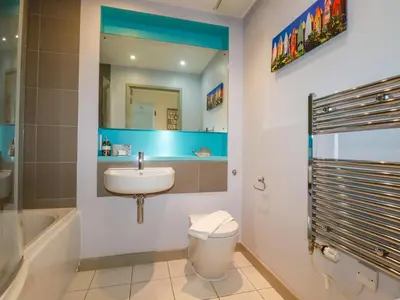 a bathroom with a sink and a toilet and a mirror at 33 Tre Lowen in Newquay