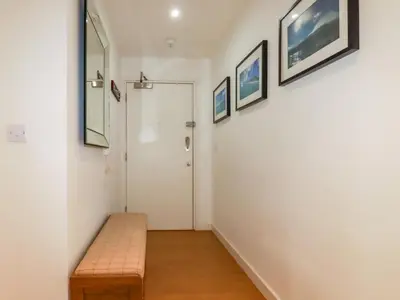 a hallway with a bench and pictures on the wall at 33 Tre Lowen in Newquay