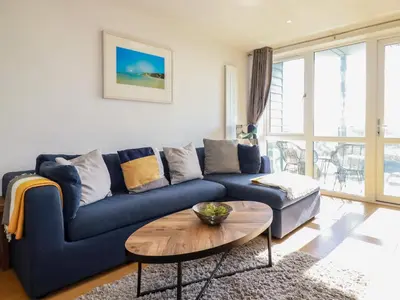 a blue couch in a living room with a table at 33 Tre Lowen in Newquay