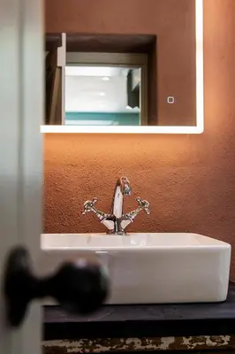 a bathroom sink with a faucet in front of a mirror at Manor Cottage at Cusgarne Manor, romantic, dog-friendly in Cusgarne