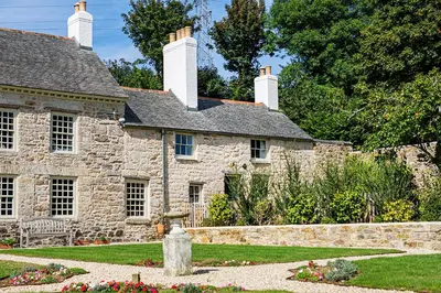 an old stone house with a garden in front of it at Manor Cottage at Cusgarne Manor, romantic, dog-friendly in Cusgarne
