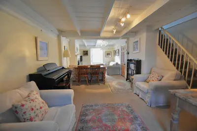 a living room with couches and a piano at Morning Cottage in St Ives