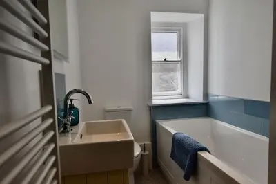 a bathroom with a sink and a tub and a toilet at Morning Cottage in St Ives