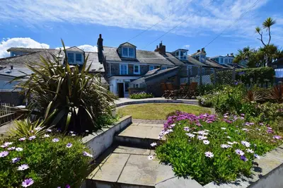 a garden with flowers in front of a house at Morning Cottage in St Ives