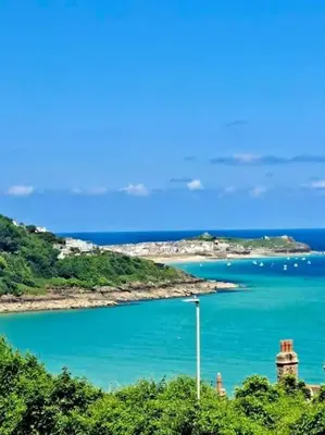 a view of a body of water with a lighthouse at The Lookout in Carbis Bay