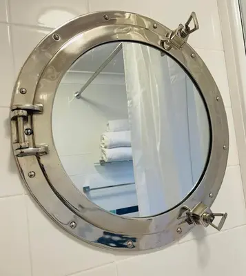 a bathroom mirror with a metal frame on a wall at The Lookout in Carbis Bay