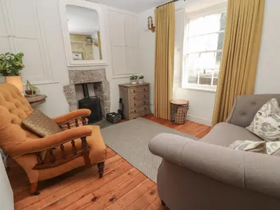a living room with a couch and a fireplace at Apple Tree Cottage in Helston