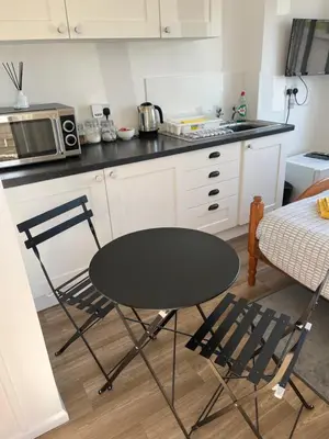 a kitchen with a black table and two chairs at Hellfire corner in Redruth