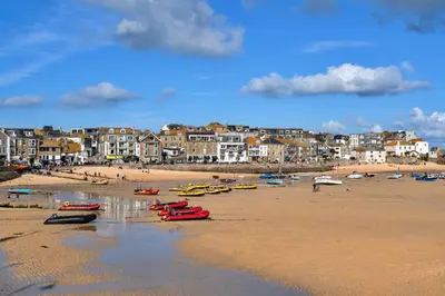 a beach with boats on the sand and buildings at Finest Retreats - No 6 Porthgwidden in St Ives