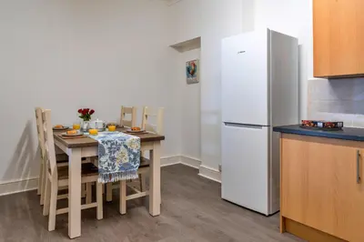 a kitchen with a table with chairs and a refrigerator at Finest Retreats - No 6 Porthgwidden in St Ives