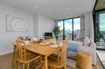 a dining room and living room with a table and chairs at 14 An Garth in Hayle