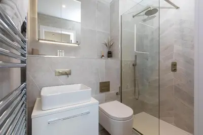 a bathroom with a toilet and a glass shower at 14 An Garth in Hayle