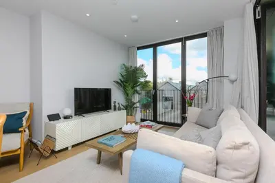 a living room with a white couch and a tv at 14 An Garth in Hayle